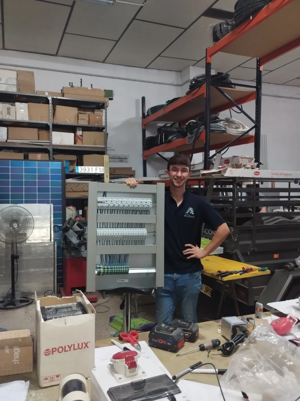 Técnico de ACIPro junto a un cuadro de control terminado en el taller